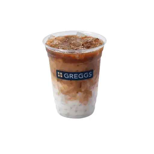 Greggs Menu And Updated Prices In UK 2025 64 A clear cup of Greggs iced latte with ice cubes, creamy espresso swirling through chilled milk, topped with a smooth, frothy layer.